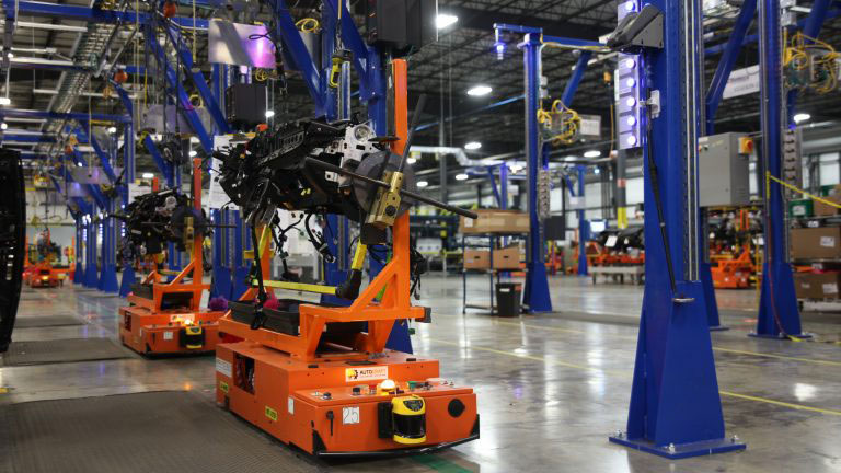 Autocraft Autonomous Guided Vehicles (AGVs) produced by Eckhart Inc. navigate a factory floor.